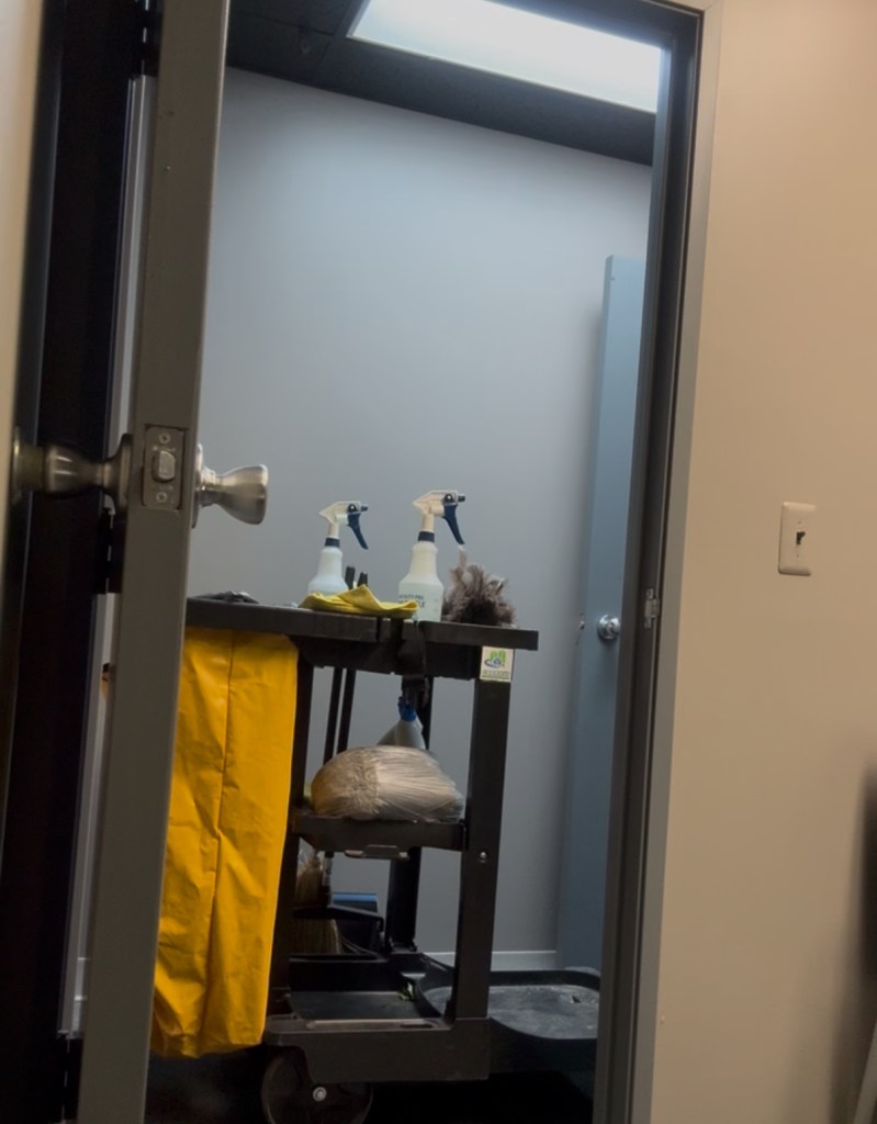 Janitorial cleaning cart positioned outside an office